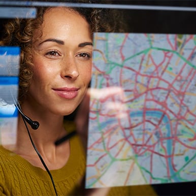 Woman online with headset tracking a routed delivery.